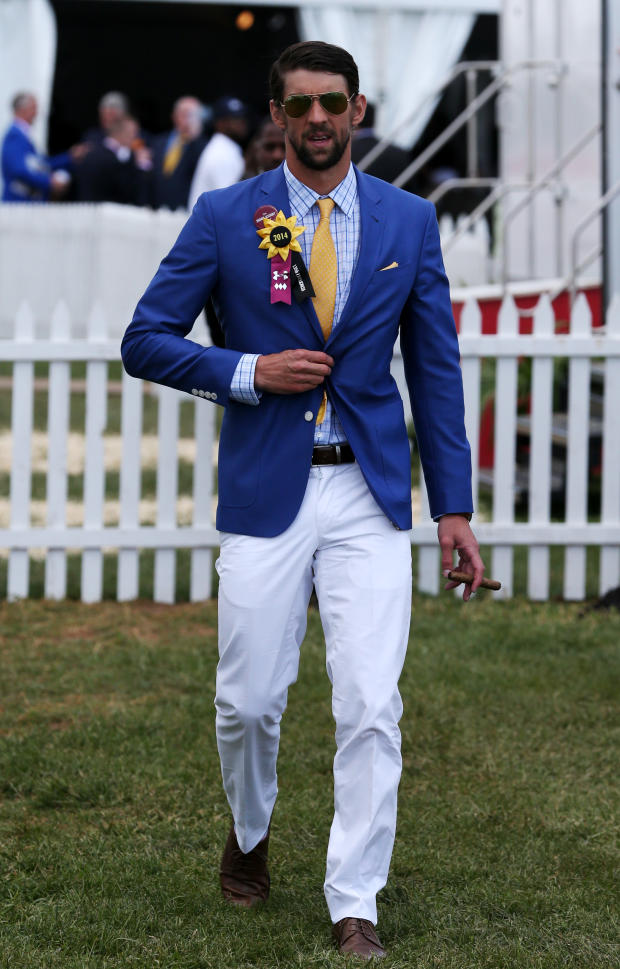 USA swimmer Michael Phelps walks through infield before the 139th Preakness Stakes at Pimlico Race Course in Baltimore May 17, 2014. 