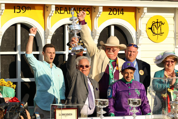 California Chrome trainer Art Sherman, holding trophy, jockey Victor Espinoza and owner Steven Coburn celebrate after winning the 139th Preakness Stakes at Pimlico Race Course in Baltimore May 17, 2014. 