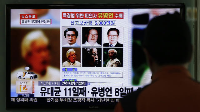 A TV news program shows the reward poster for billionaire Yoo Byung-eun at the Seoul Train Station 