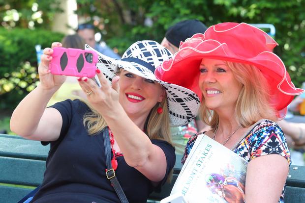 Nicole Slavek, left, and Barb Traxler of Minnesota take their own photograph before the 2014 Belmont Stakes at Belmont Park in Elmont, New York, June 7, 2014. 