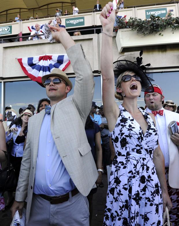 Josh Ness and Sally Ness, both of Ithaca, New York, cheer during the seventh race before the 2014 Belmont Stakes at Belmont Park in Elmont, New York, June 7, 2014. 