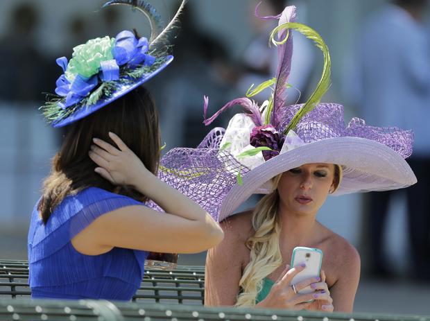 Two ladies enjoy the atmosphere in their hats prior to the 146th running of the Belmont Stakes at Belmont Park in Elmont, New York, June 7, 2014. 