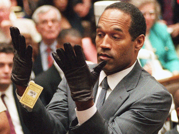 O.J. Simpson holds up his hands before the jury after putting on a new pair of gloves similar to the infamous bloody gloves during his double-murder trial in Los Angeles on June 21, 1995. 