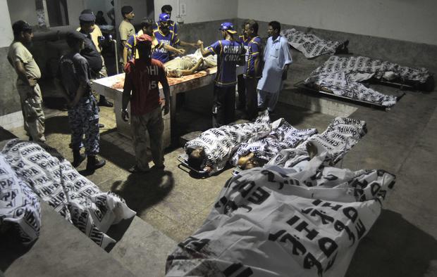 Rescue workers and paramilitary soldiers gather next to bodies after an attack on Jinnah International Airport, at a hospital morgue in Karachi 