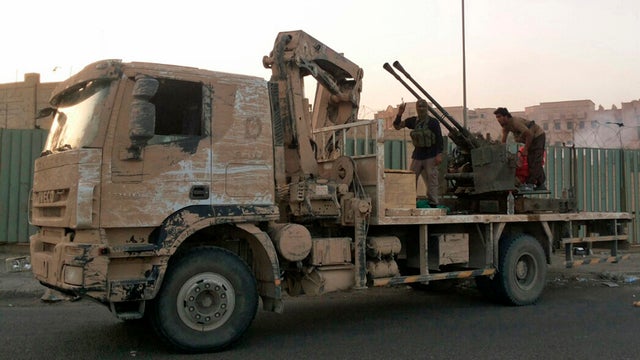 Fighters of the Islamic State of Iraq and al Sham (ISIS) patrol on a vehicle fitted with an anti-aircraft gun in Tikrit 