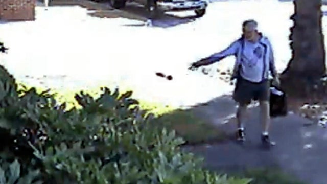 Dennis Kneier, then mayor of San Marino, Calif., tosses a bag of dog waste onto the property of his neighbor, Philip Lao, in San Marino June 7, 2014, in this security video image provided by Lao. 