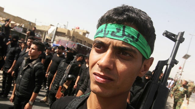 Iraqi Shiite fighters parade with their weapons June 21, 2014, in the capital, Baghdad. 