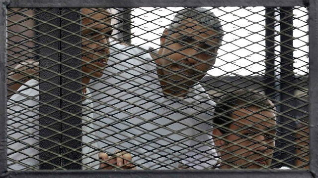 Peter Greste, Mohamed Fahmy and Baher Mohamed (L-R) listen to the ruling at a court in Cairo 