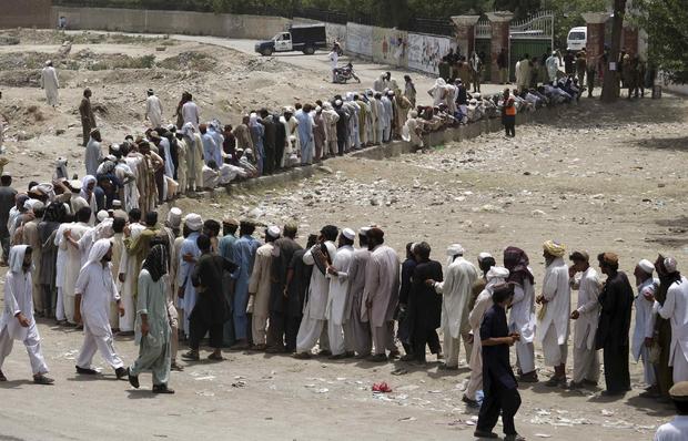 People who fled the military offensive against Pakistani militants in North Waziristan line up to receive food from the army in Bannu, in Pakistan's Khyber Pakhtunkhwa province 