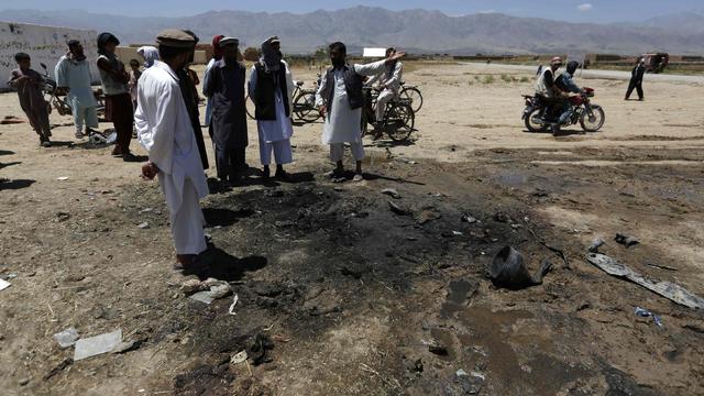 Afghan villagers stand at the site of an attack in Parwan province 