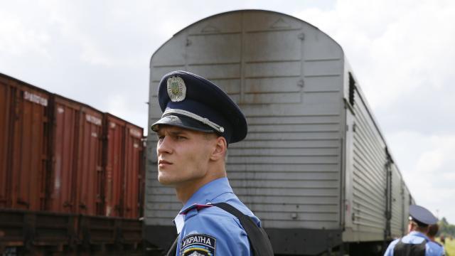 A Ukrainian policeman watches as a train carrying the remains of the victims of Malaysia Airlines MH17 downed over rebel-held territory in eastern Ukraine arrives in the city of Kharkiv 