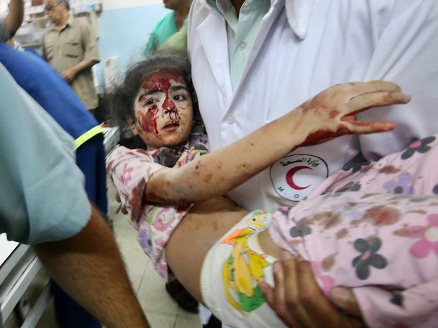 A Palestinian medic carries a girl who medics said was wounded by Israeli shelling, at a hospital in Khan Younis in the southern Gaza Strip