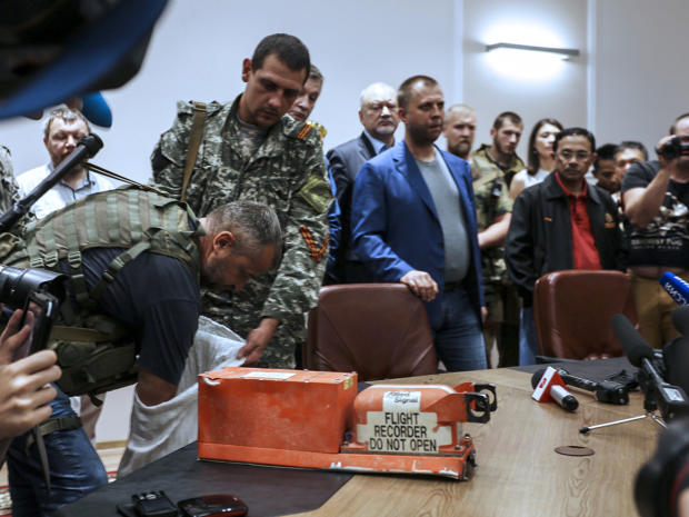 A pro-Russia separatist shows members of the media a black box belonging to Malaysia Airlines Flight 17 before handing it over to Malaysian representatives during a press conference in Donetsk, Ukraine, July 22, 2014. 