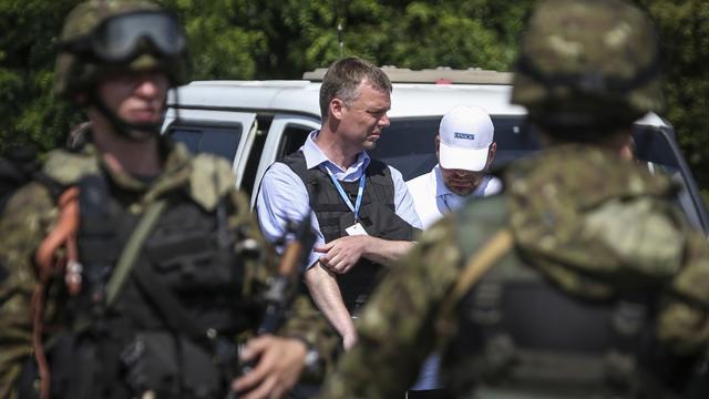 Alexander Hug of the (OSCE) monitoring mission in Ukraine, looks on next to armed pro-Russian separatists on the way to the site in eastern Ukraine where the downed Malaysia Airlines flight MH17 crashed 
