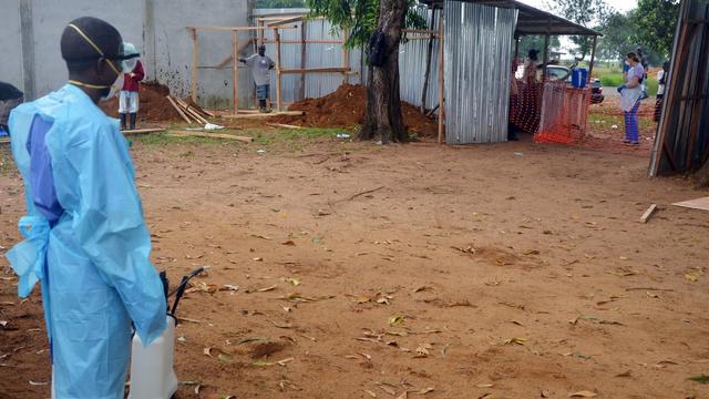 Staff member of Christian charity Samaritan's Purse carries spray gun as he treats area at entrance of the ELWA hospital in the Liberian capital of Monrovia in July 2014 