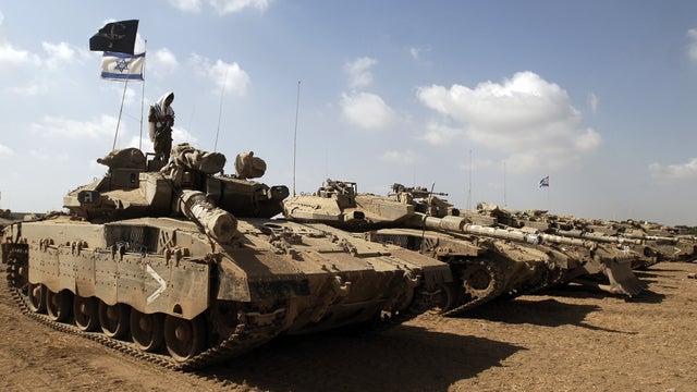 An Israeli soldier prays on a tank at a position a couple miles from the Israel-Gaza border 