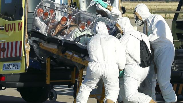 Health workers load Ebola patient, Spanish priest Miguel Pajares, into an ambulance on the tarmac of Torrejon airbase in Madrid 