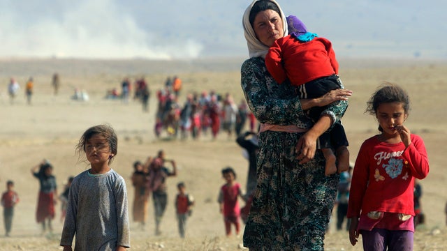 Displaced people from the minority Yazidi sect, fleeing ISIS militants in Sinjar town, walk toward the Syrian border 