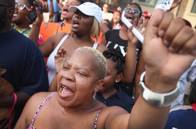 Roxann Evans joins other demonstrators protesting in the street where teenager Michael Brown was killed Aug. 14, 2014, in Ferguson, Missouri.