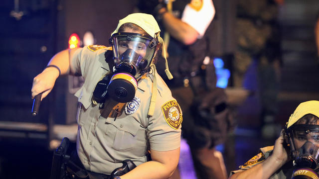 Police put on riot gear to confront demonstrators during a protest over the shooting of Michael Brown Aug. 15, 2014, in Ferguson, Missouri. 