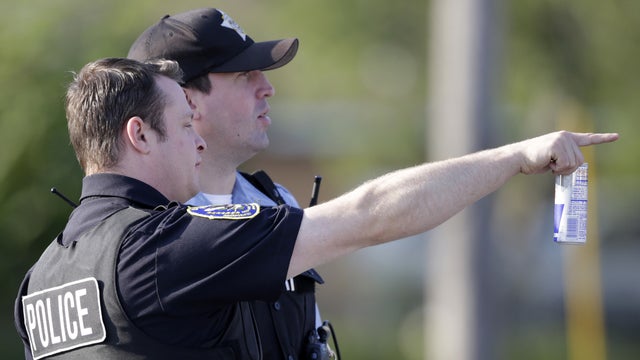 ​Police stage at an intersection as law enforcement officials negotiate with at least one hostage-taker a house in the southern Chicago suburb of Harvey Aug. 20, 2014. 