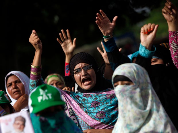 Supporters of Tahirul Qadri, Sufi cleric and leader of political party Pakistan Awami Tehreek (PAT), gesture as they chant slogans during the Revolution March in Islamabad Aug. 18, 2014.