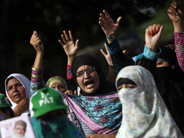 Supporters of Tahirul Qadri, Sufi cleric and leader of political party Pakistan Awami Tehreek (PAT), gesture as they chant slogans during the Revolution March in Islamabad Aug. 18, 2014. 