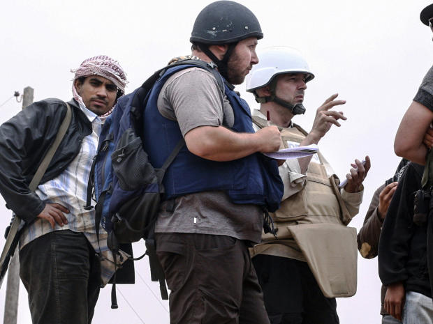 American journalist Steven Sotloff, center with black helmet, talks to Libyan rebels on the Al Dafniya front line 25 kilometers west of Misrata, June 2, 2011, in Misrata, Libya, in this handout image made available by the photographer 