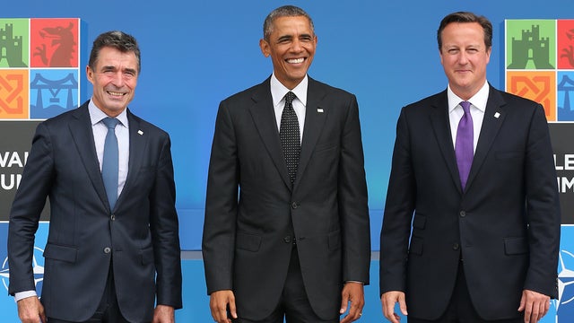 President Obama stands with NATO Secretary General Anders Fogh Rasmussen (L) and British Prime Minister David Cameron at the NATO Summit 
