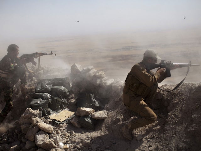 Iraqi Kurdish Peshmerga fighters fire at ISIS militant positions, from their position on the top of Mount Zardak, a strategic point taken 3 days before, about 15 miles east of Mosul on September 9, 2014 