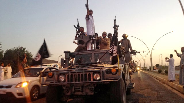 Fighters from the group known as the Islamic State of Iraq and Syria parade in a commandeered Iraqi security forces armored vehicle down a main road in the northern city of Mosul, Iraq, June 23, 2014. 