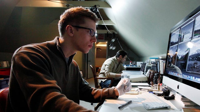 John Maloof uses a computer to digitally processes negatives taken by Vivian Maier at his home in Chicago, helped by Tony Ryzdon, background, Jan. 6, 2011. 