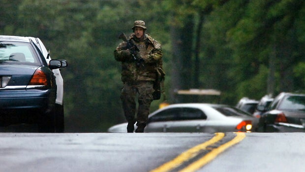 ​A member of the Pennsylvania State Trooper's Tactical Response Unit walks along Route 402 Sept. 13, 2014, near the scene where a Pennsylvania state trooper was killed and another trooper was injured during a shooting the previous night at the Pennsylvani 