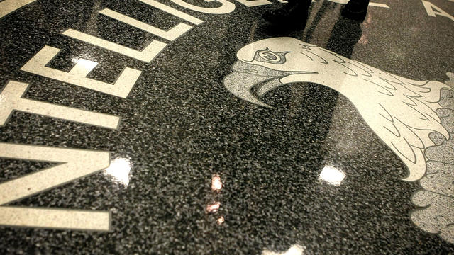 A man walks across the seal of the Central Intelligence Agency at the lobby of the Original Headquarters Building at the CIA headquarters Feb. 19, 2009, in McLean, Virginia. 