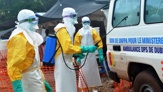 Health workers disinfect a van at the Doctors Without Borders center in Conakry, Guinea, Sept. 13, 2014. 