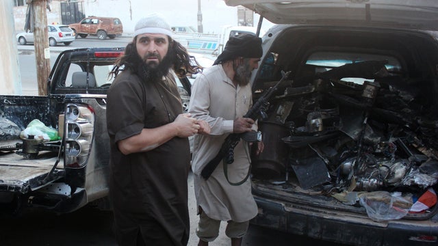 Fighters from the Islamic State of Iraq and Syria group load a van with parts that they said was from a U.S. drone that crashed into a communications tower in Raqqa, Syria, Sept. 23, 2014. 