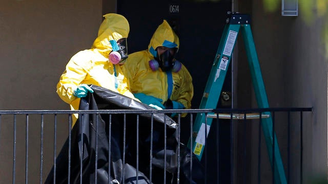 Workers wearing hazardous material suits arrive at the apartment unit where a man diagnosed with the Ebola virus was staying in Dallas, Texas, Oct. 3, 2014. 