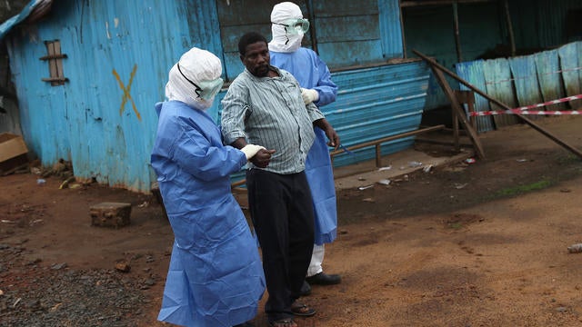 Nurses escort Ebola survivor Wilson Weh, 56, from the JFK Ebola treatment center 