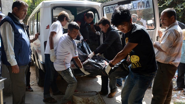 Volunteers shift the recovered body of a trekker killed in a snowstorm and an avalanche on Nepal's Annapurna Circuit, at the Teaching Hospital morgue in Kathmandu 