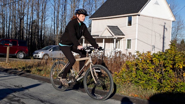 Nurse Kaci Hickox rides away from the home she is staying in on a rural road in Fort Kent, Maine, to take a bike ride Oct. 30, 2014. 