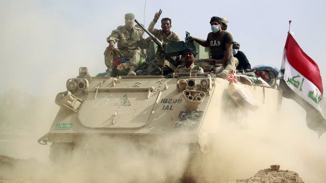 Iraqi forces on an armored personnel carrier advance in the Jurf al-Sakhr area, north of the Shiite shrine city of Karbala Oct. 30, 2014, after retaking the area from ISIS jihadists. 