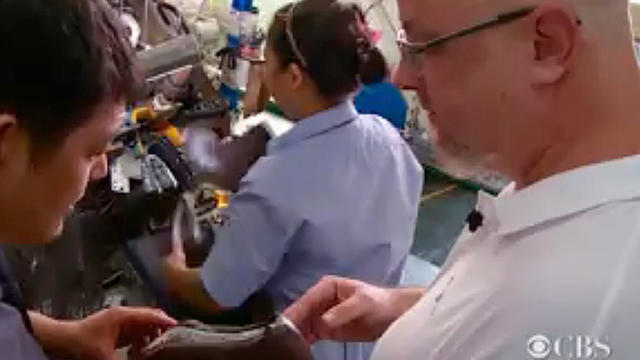 ​American shoe designer Bob Gwynne talks to a factory employee 