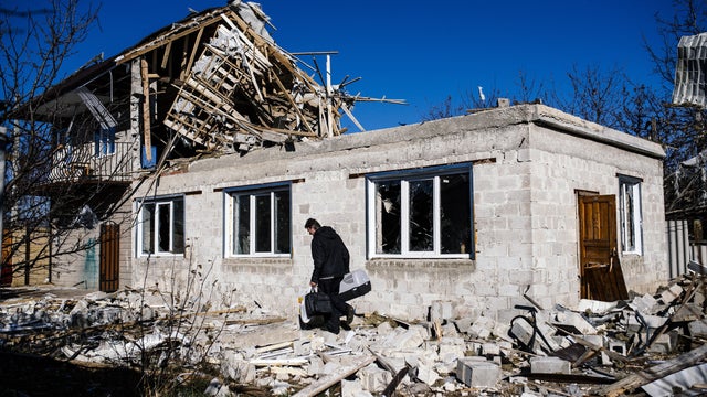 A man carries his belongings as passes by his destroyed home following shelling in the Kuybeshevski area in Donetsk on November 6, 2014. 