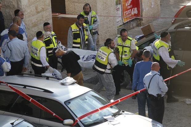 Israeli emergency service volunteers carry the body of a Palestinian assailant who was shot dead while attacking a synagogue in the ultra-Orthodox Har Nof neighborhood in Jerusalem 