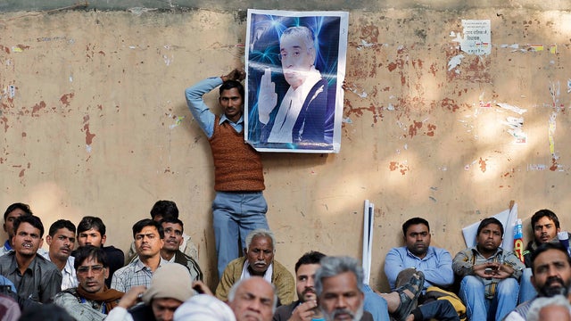 A supporter hold a photograph of Sant Rampal, a self-styled "godman" as he takes part in a protest march in New Delhi 