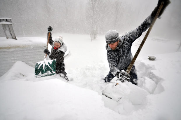 Tami Normile and Richard Brooks attempt to remove some of the five feet of snow from a rooftop Nov. 20, 2014, in the Lakeview neighborhood of Buffalo, N.Y. 