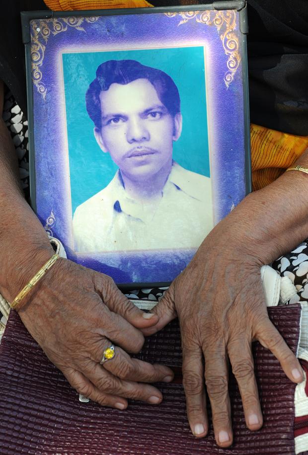 Bhopal gas disaster survivor Chironjee Bai Thakur holds a photograph of her late husband, Maharja Singh, during a protest rally in Bhopal Dec. 2, 2014. 