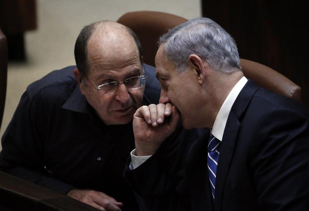 Israeli Prime Minister Benjamin Netanyahu (R) discusses with Israeli Defense minister Moshe Yaalon before the ultimate vote to dissolve the Israeli Parliament at the Knesset in Jerusalem 