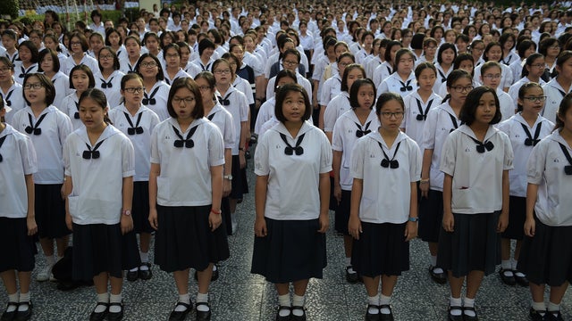 Thai female students sing the national anthem in the courtyard of the Satriwithaya school in downtown Bangkok 