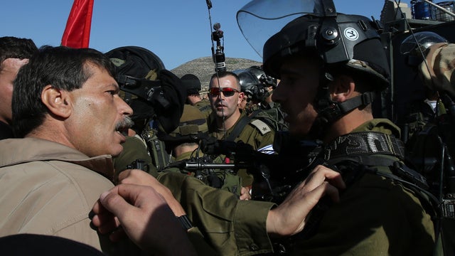 Palestinian official Ziad Abu Ein (L), in charge of the issue of Israeli settlements for the Palestinian Authority, argues with Israeli soldiers during a demonstration in the village of Turmus Aya near Ramallah 